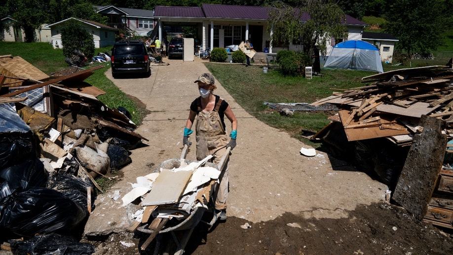 A volunteer helps clean up debris following floods in Kentucky.