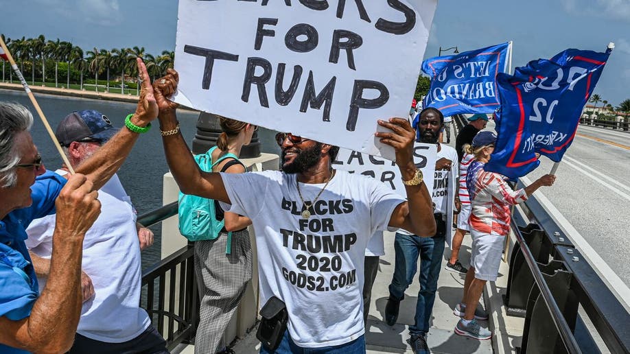 Supporters of former US President Donald Trump walk near his residence