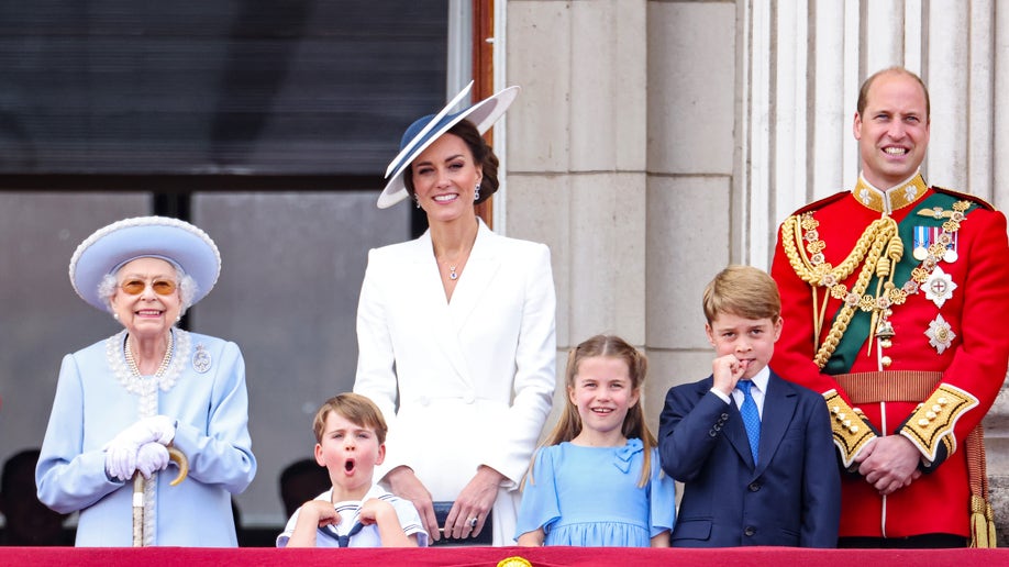 British Royals, including Kate, William, George, Charlotte, Louis, and the Queen stand on Buckingham Palace balcony