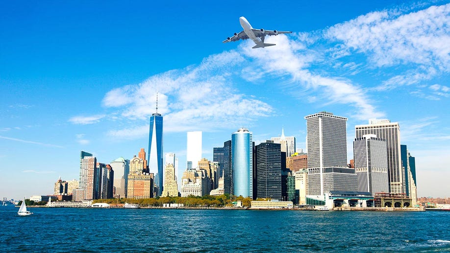 An airplane flies over the Manhattan skyline
