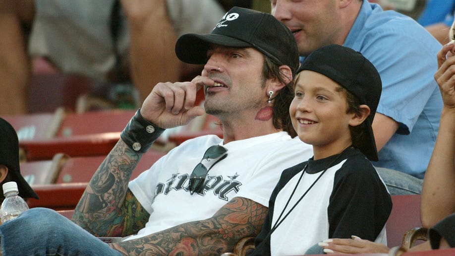 Tommy Lee sitting with his son Brandon Thomas in 2003