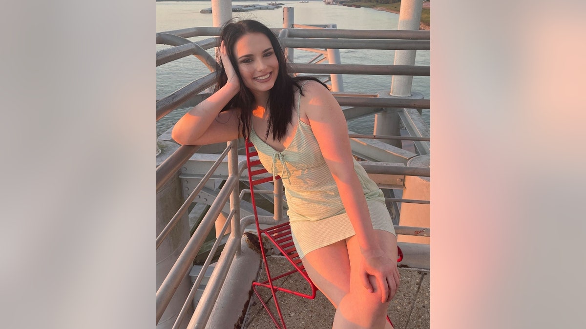 Allison Rice sitting on a red chair and smiling