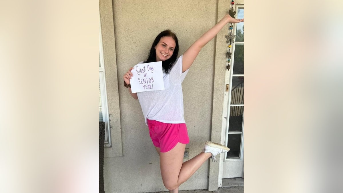 Allison Rice poses with a sign that reads, 'Senior Day'