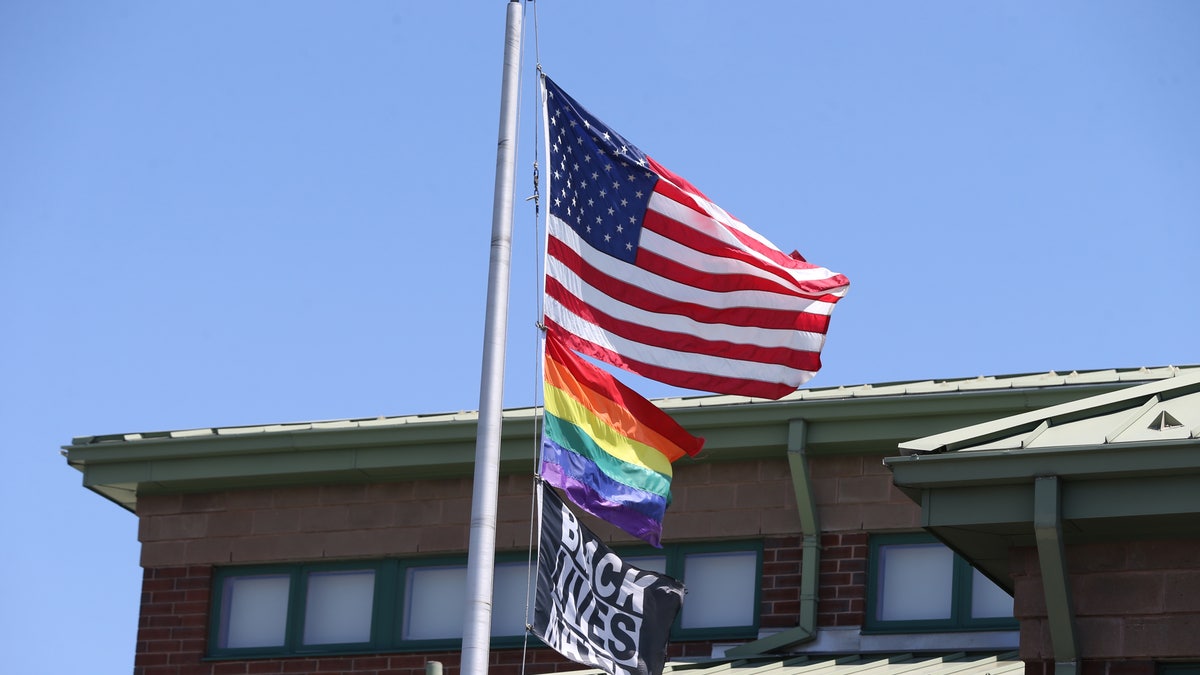 The U.S. flag, the rainbow pride flag and a Black Lives Matter flag fly over The Nativity School of Worcester. (Photo by Jonathan Wiggs/The Boston Globe via Getty Images)