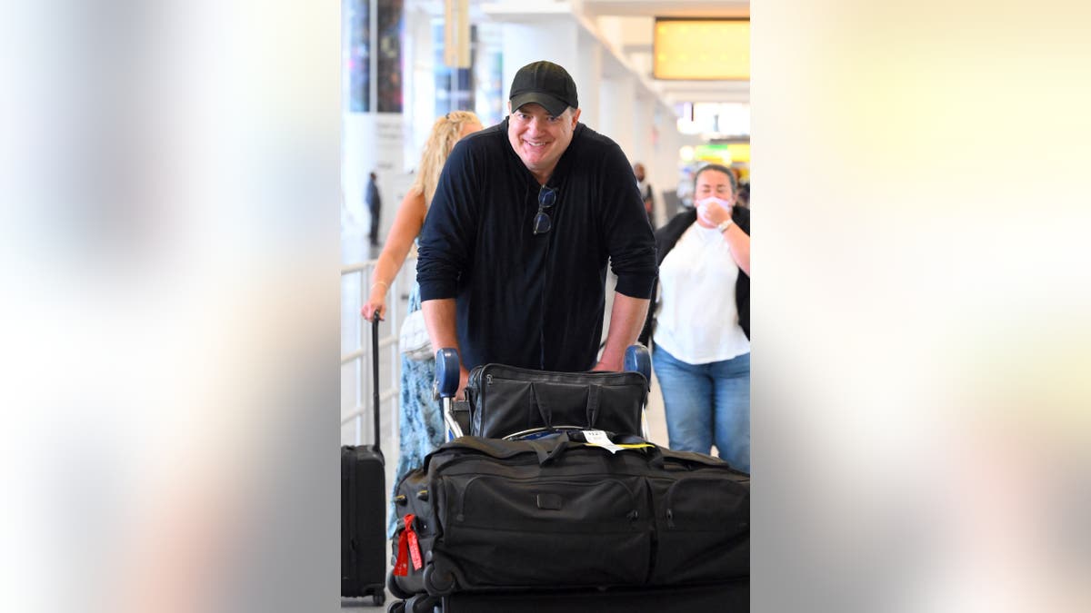Brendan Fraser smiles at airport