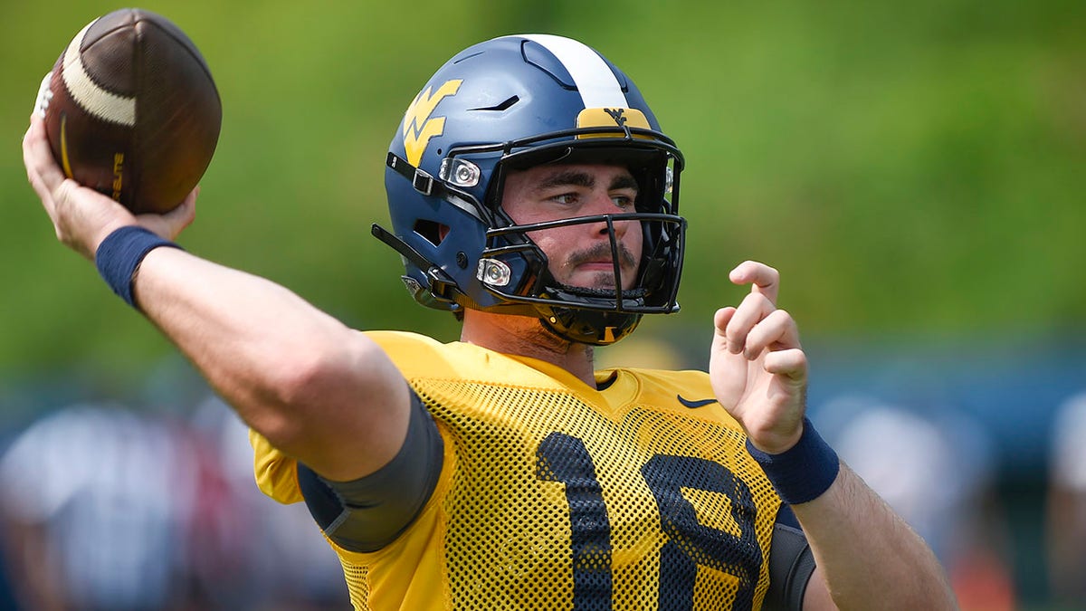 West Virginia quarterback JT Daniels throws a pass during practice