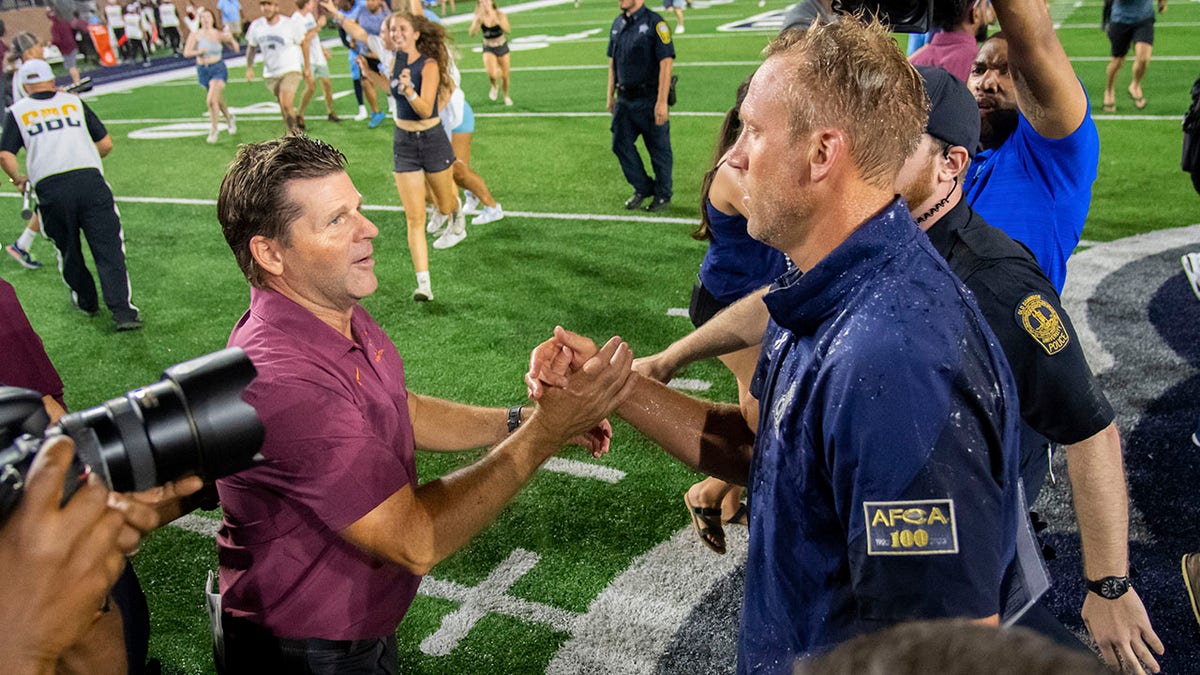 Old Dominion coach Ricky Rahne shakes hands with Brent Pry 
