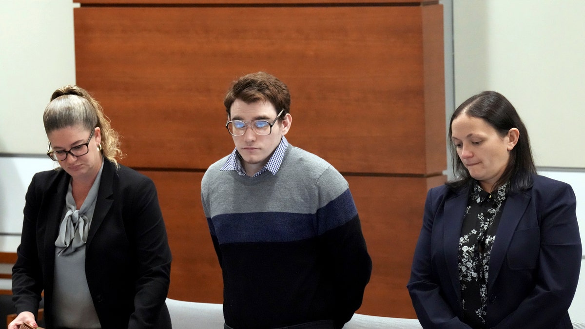 Marjory Stoneman Douglas High School shooter Nikolas Cruz, center, stands with members of his defense team