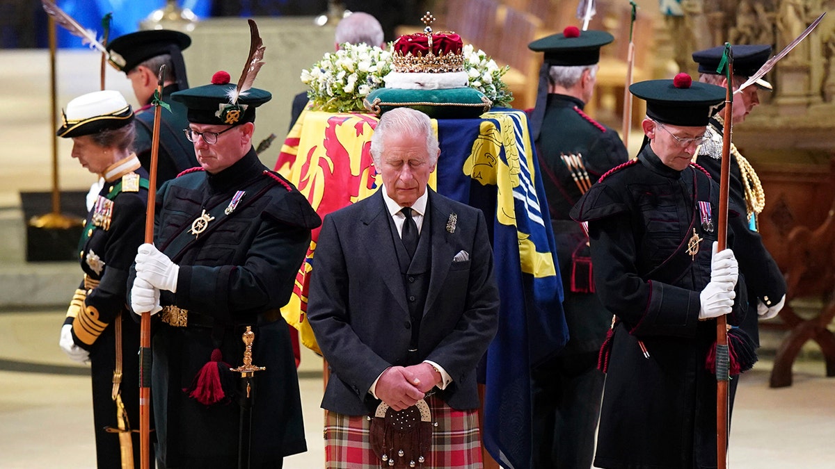 Britain's King Charles III, center, and other members of the royal family hold a vigil