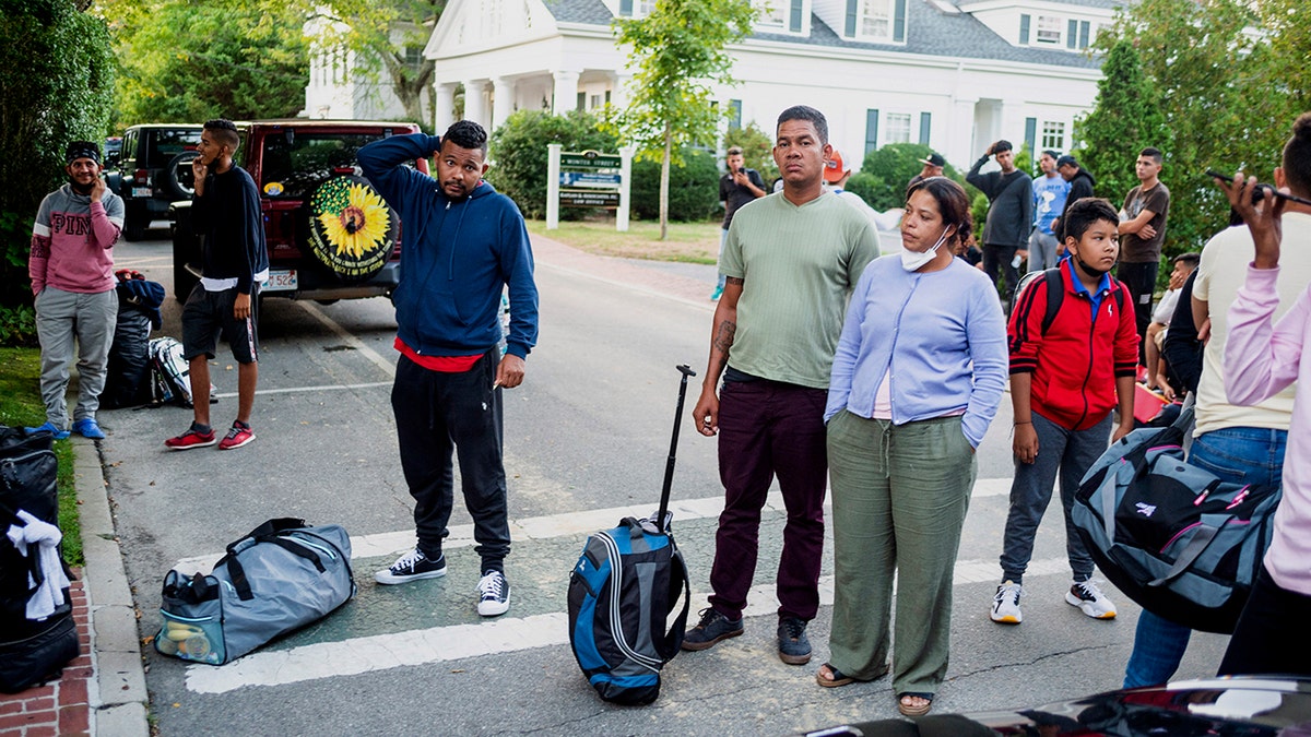 Migrants stand with their belongings in Martha's Vineyard