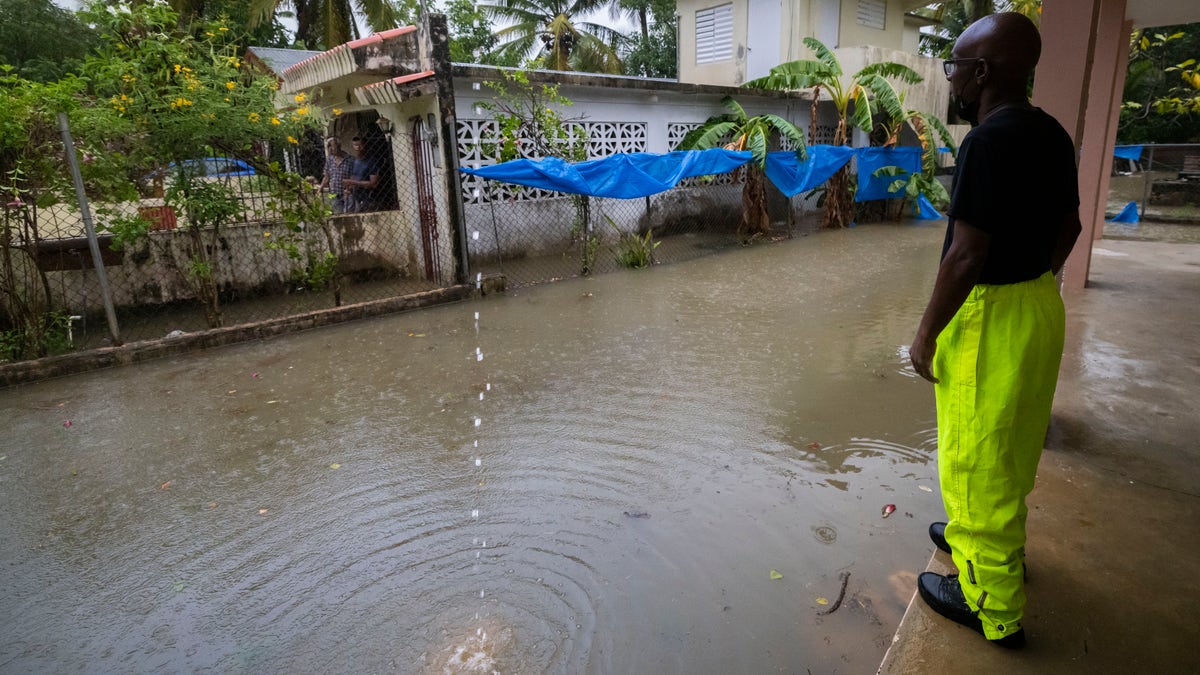 A man standing around high water caused by Hurricane Fiona in Puerto Rico