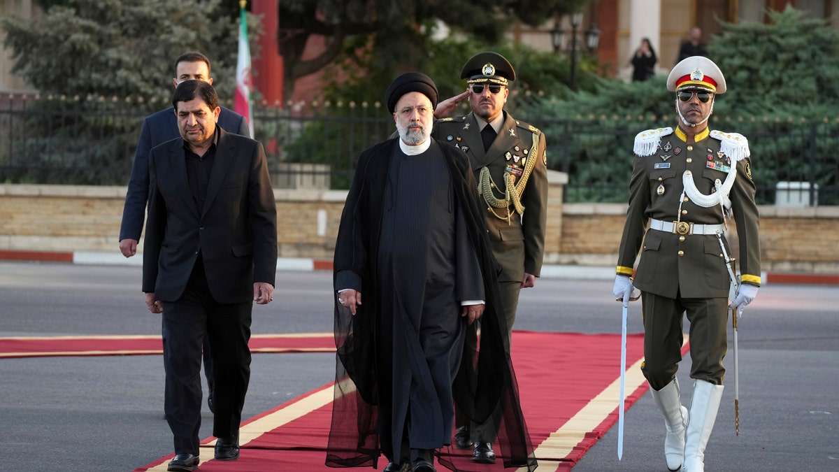 Iranian President Ebrahim Raisi walks with members of his administration