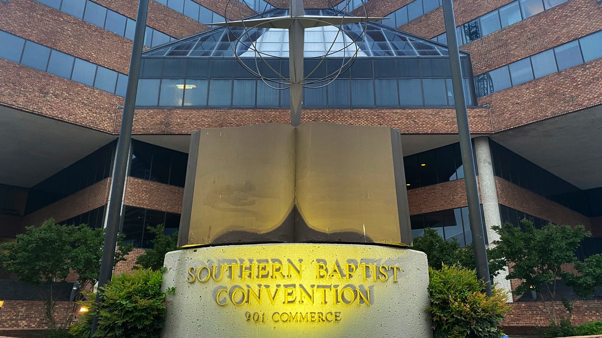 A cross and Bible sculpture stand outside the Southern Baptist Convention