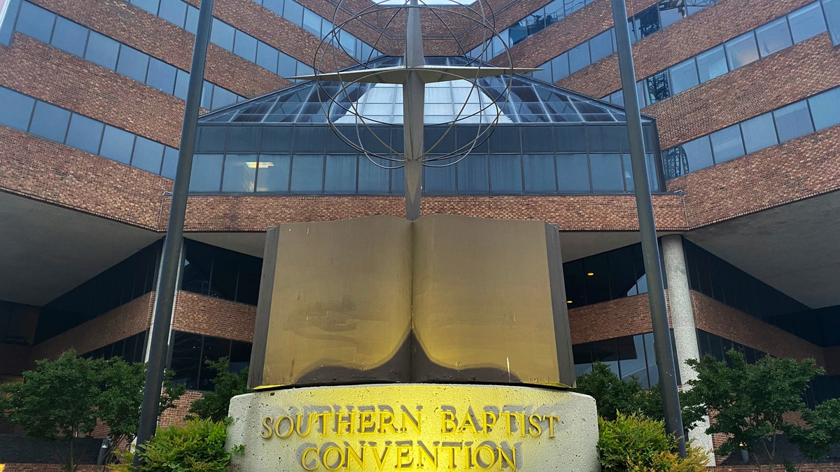 A cross and Bible sculpture stand outside the Southern Baptist Convention