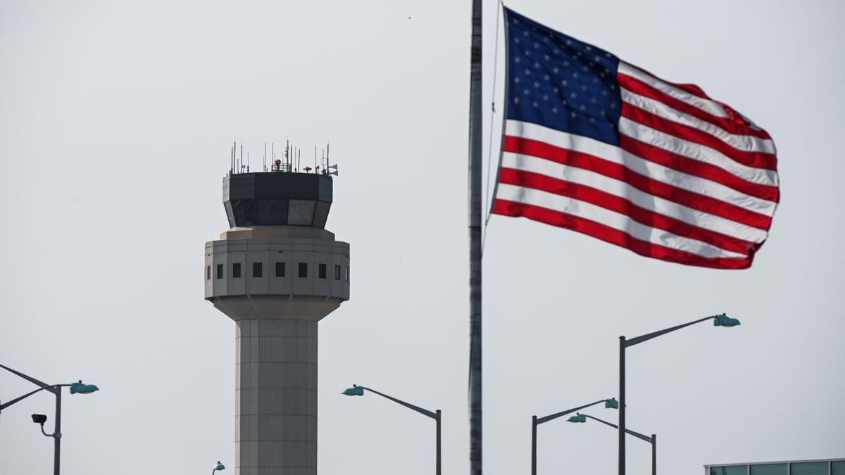 American flag flies in front of air traffic control tower in New York