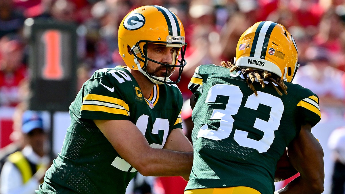 Aaron Rodgers hands the ball off