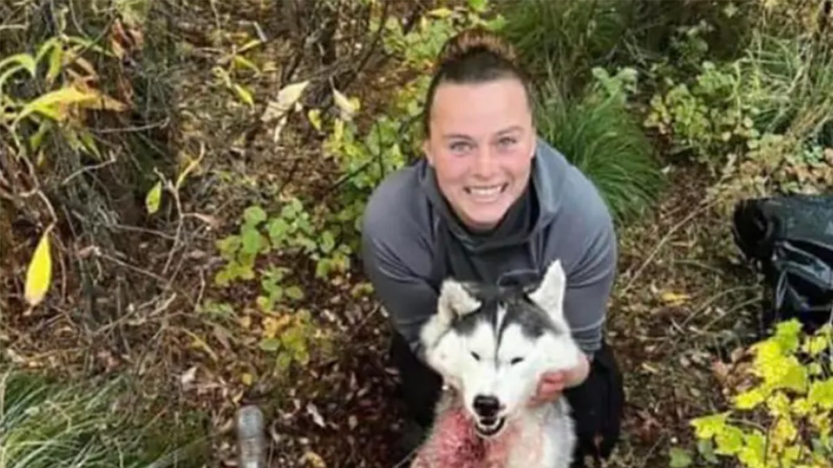Amber Rose Barnes grins as she holds a Siberian husky she shot and killed