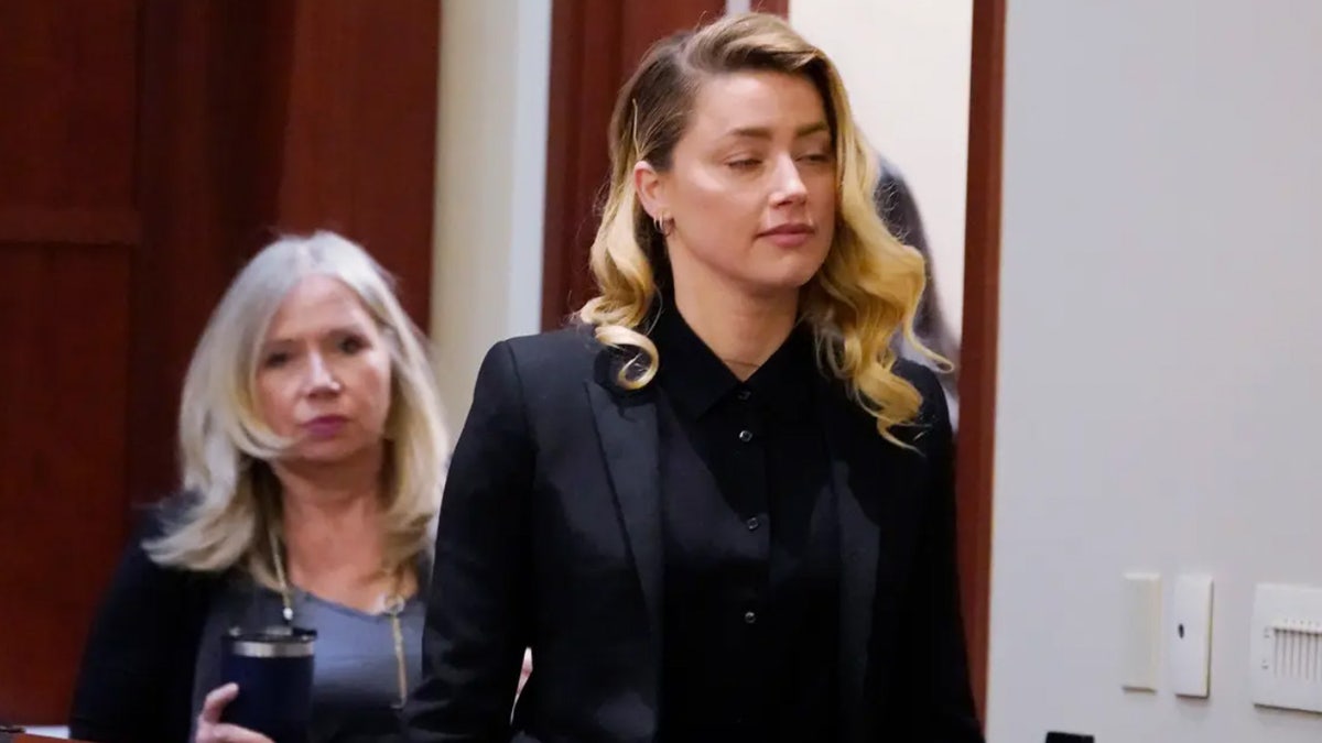 Insurance executive Pamela Johnson trails Amber Heard as she enters court