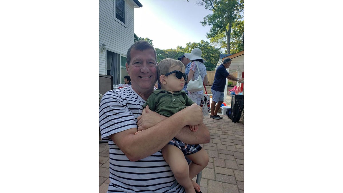 John McCauley in a striped shirt pictured with baby Dan McCauley