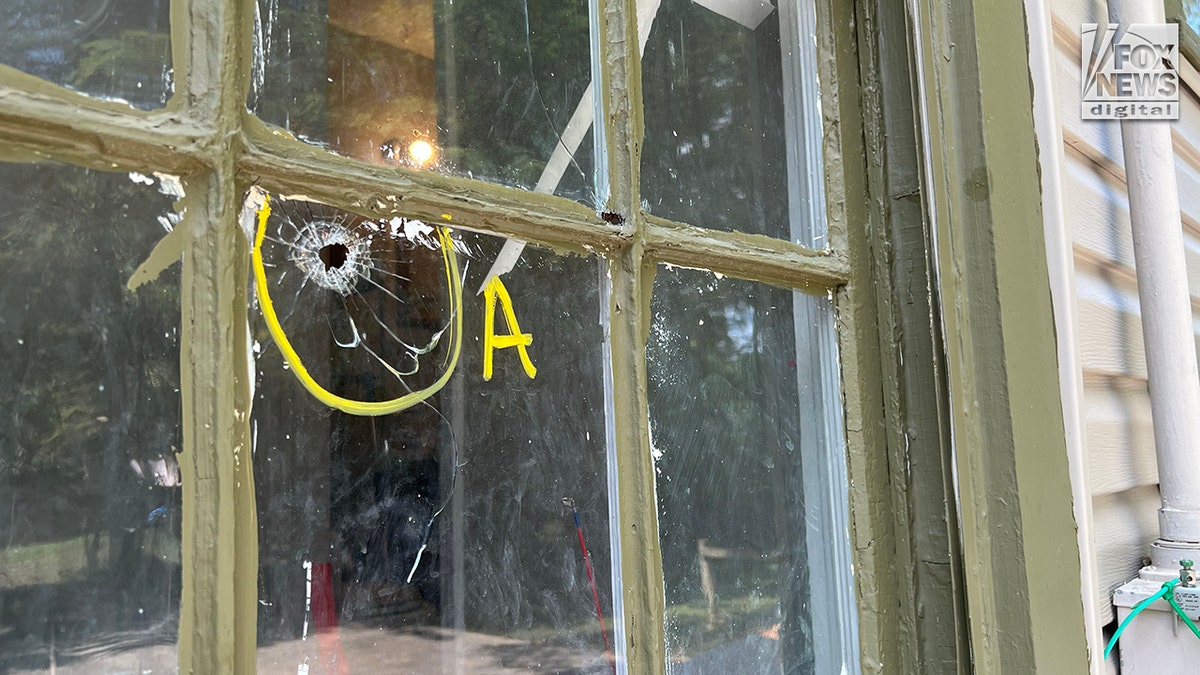 Bullet hole in a window labeled "A" by police