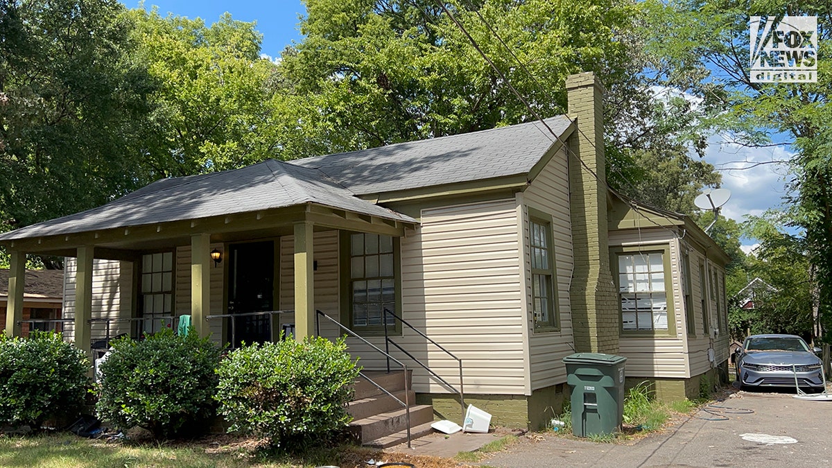 Street view of the crime scene, a small brown house with a hedge in front