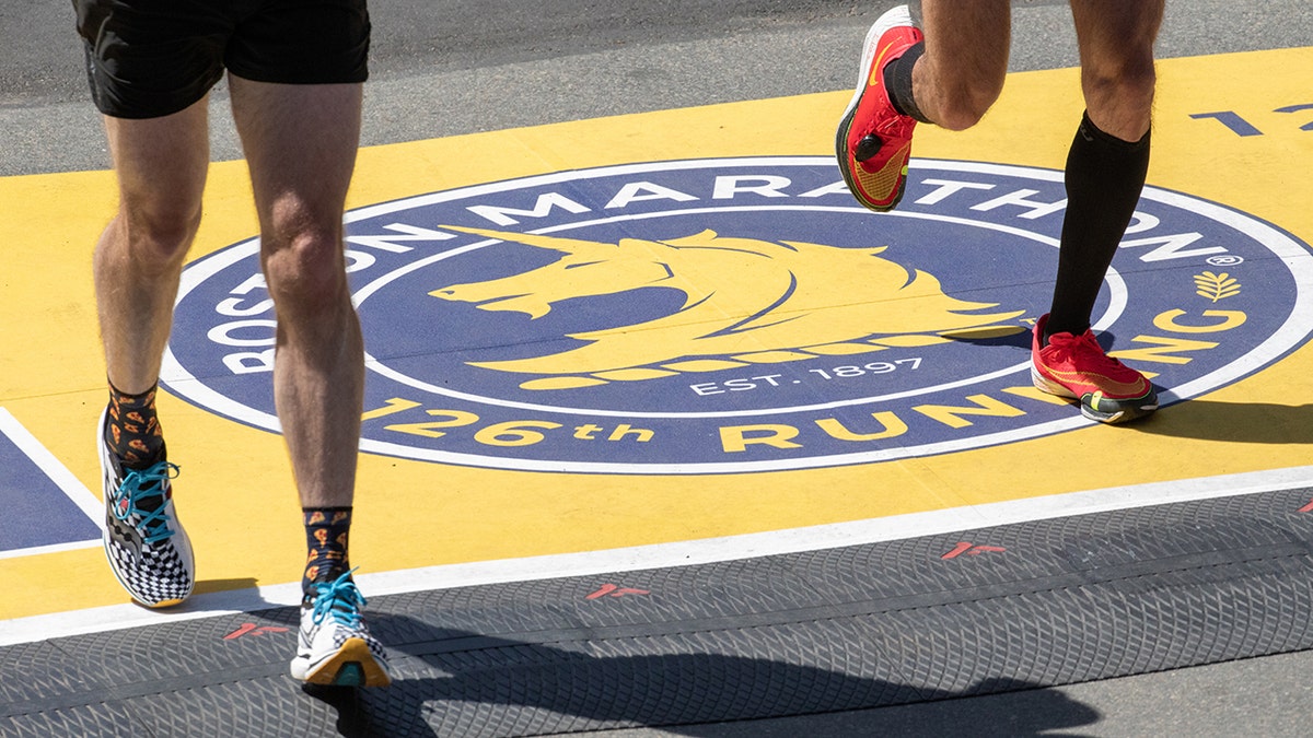 Boston Marathon sprinters cross the logo