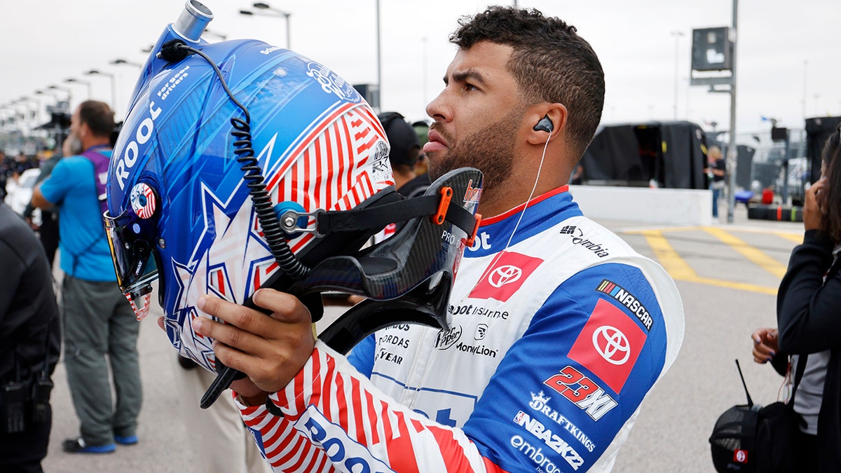 Bubba Wallace puts his helmet on