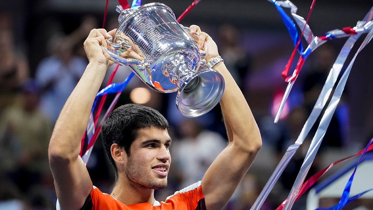 Carlos Alcaraz holds up the U.S. Open Championship trophy after winning it as a 19-year-old