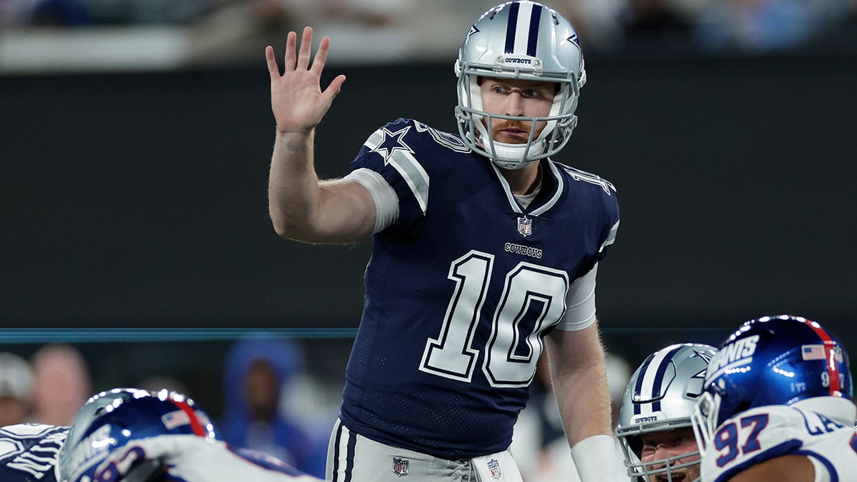 Cooper Rush motions to the offense