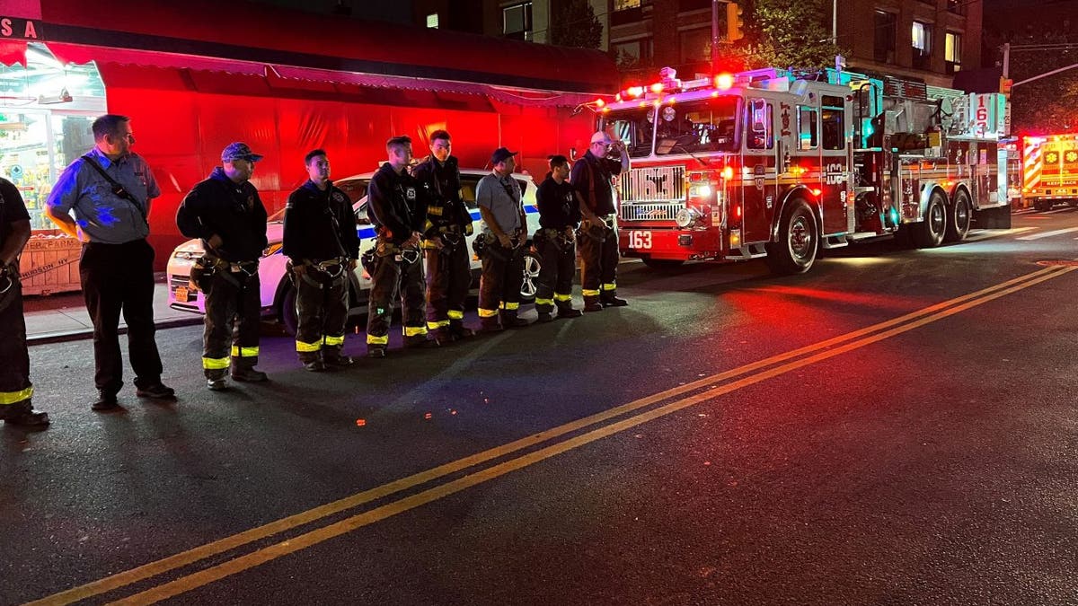 Firefighters and a fire engine in the street