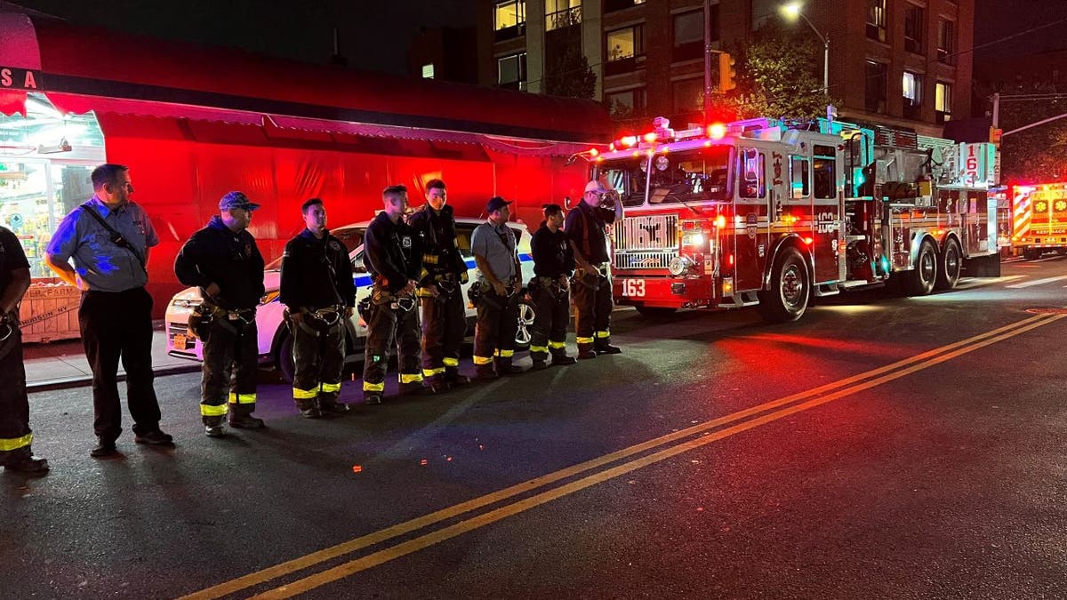 Firefighters and a fire engine in the street