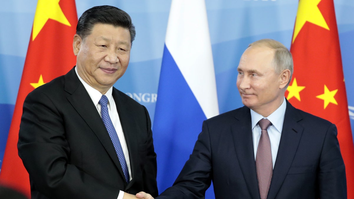 President Xi Jinping of China and Vladimir Putin of Russia shake hands.
