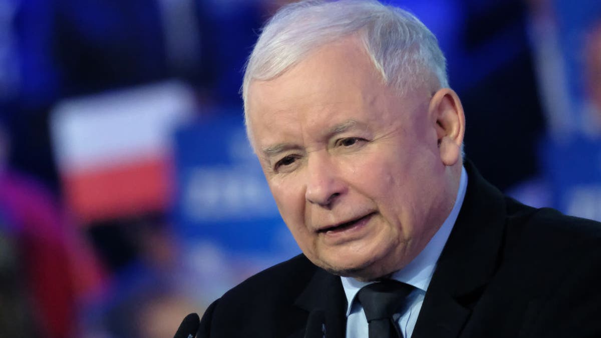 Poland's Jaroslaw Kaczynski speaks from podium, wearing a black suit