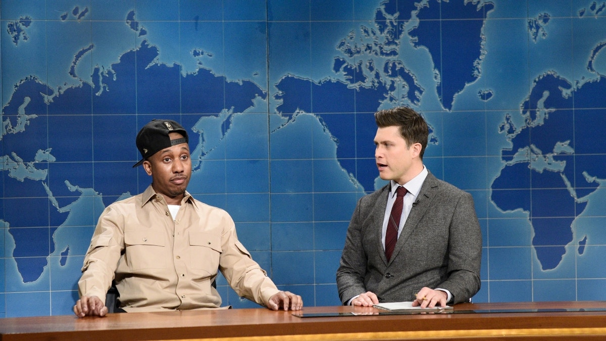 Chris Redd sitting with Colin Jost on the SNL set