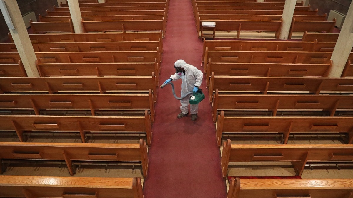 Cleaner cleaning church aisle during pandemic
