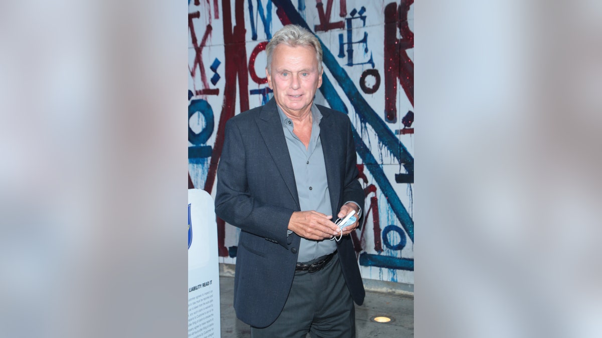 Pat Sajak holding a mask