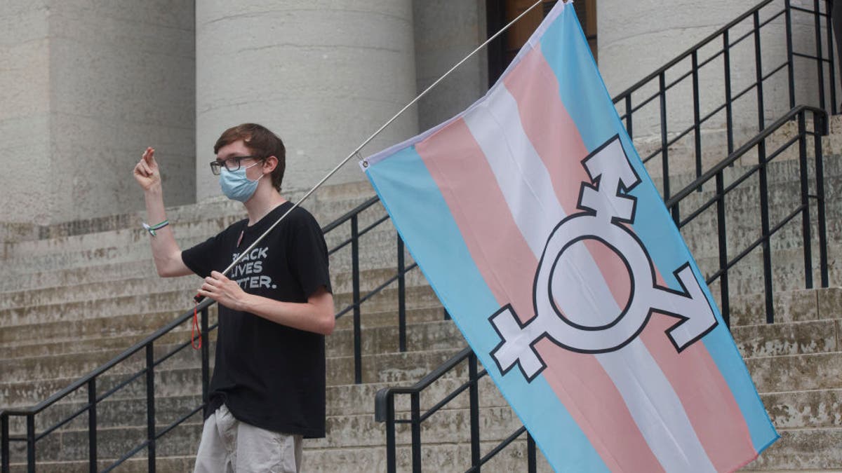 Protester with trans flag at Ohio Statehouse