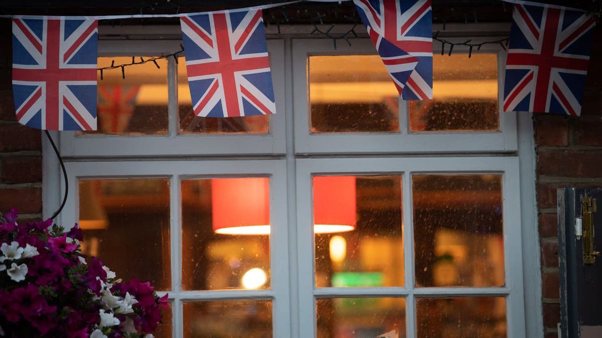 Union Jacks fly outside window of bar in England