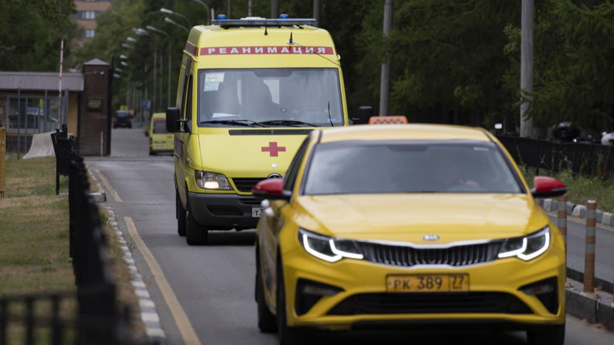 Yellow emergence vehicles drive in front of the Central Clinic Hospital
