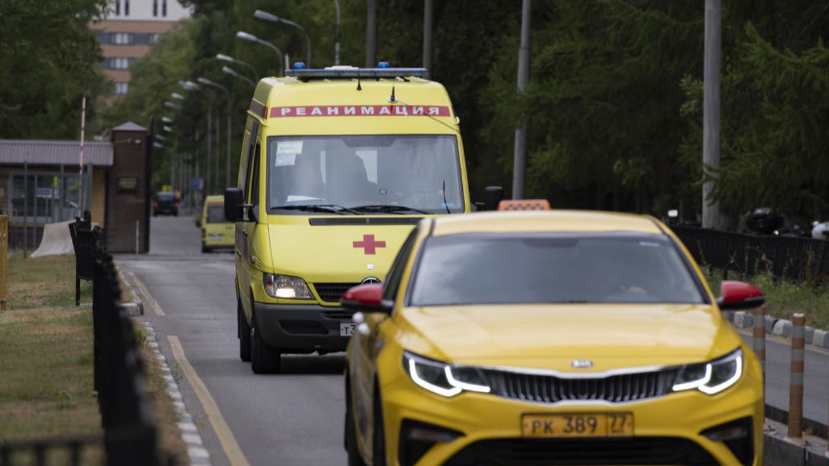 Yellow emergence vehicles drive in front of the Central Clinic Hospital