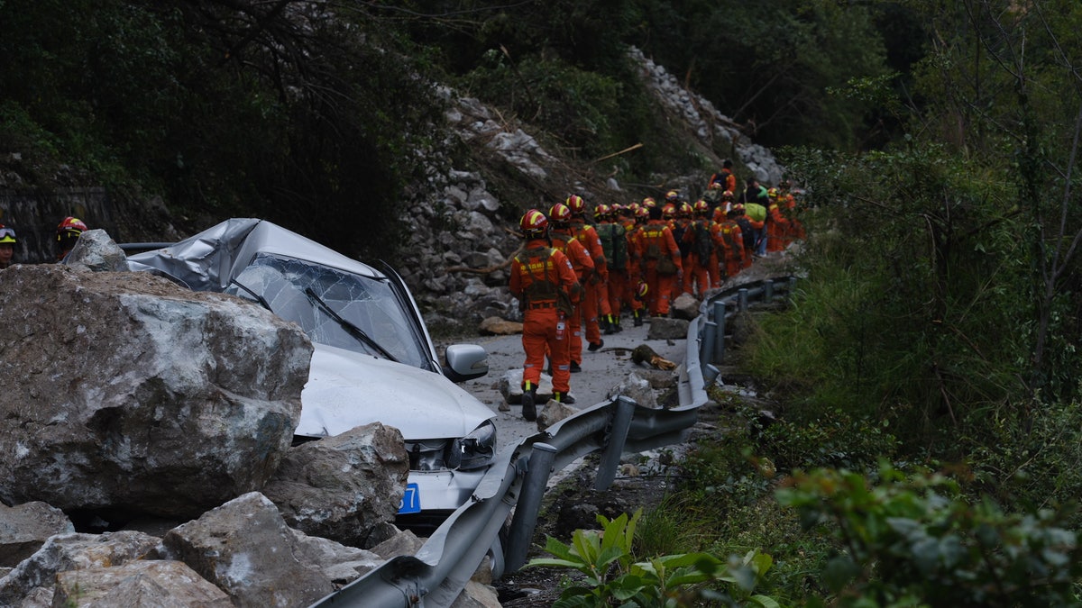 Chinese rescue workers in orange suits help earthquake victims on highway