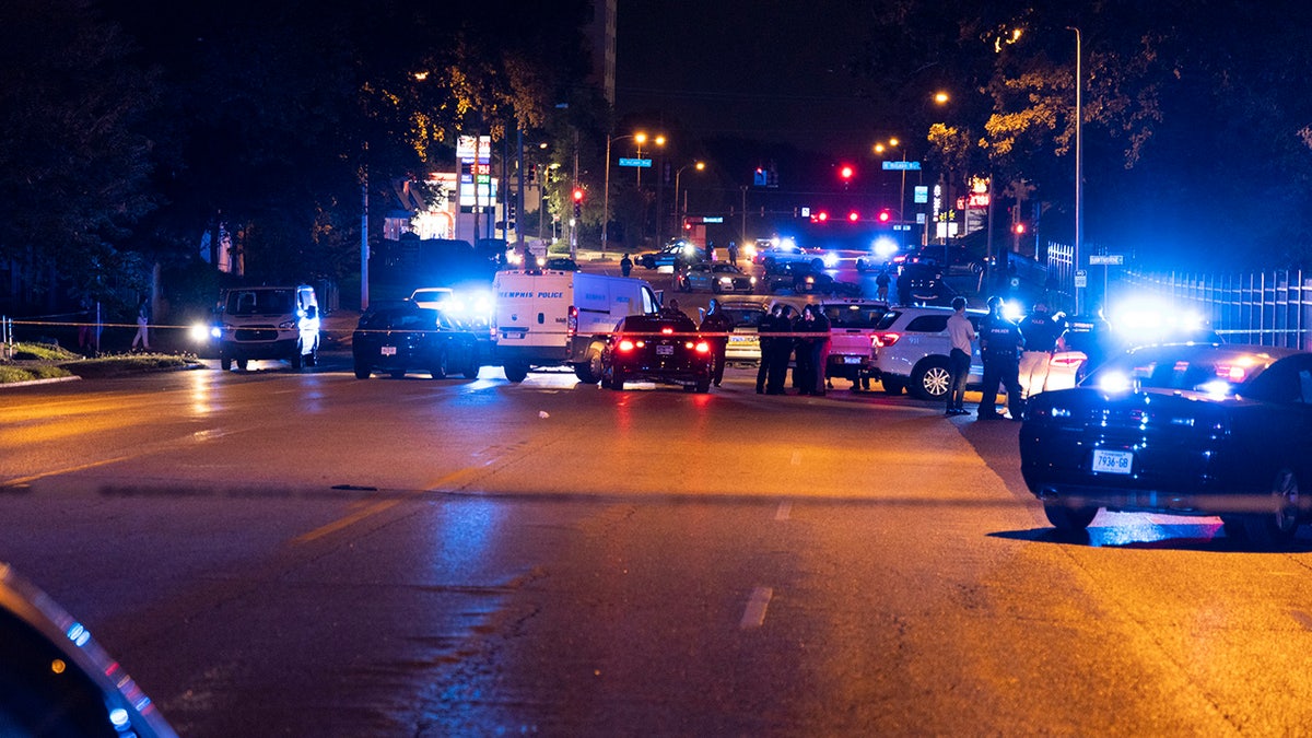 Wide shot of several police cars at shooting scene