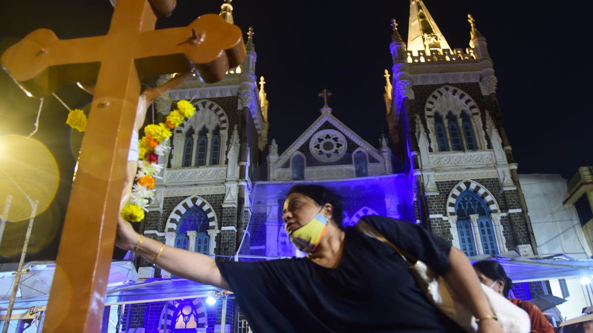 Christian touching cross during mass in Mumbai.