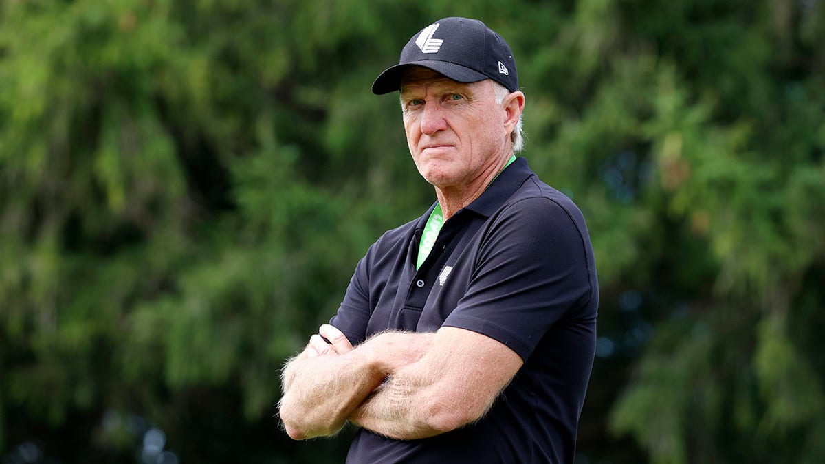 Greg Norman watches play on the third hole