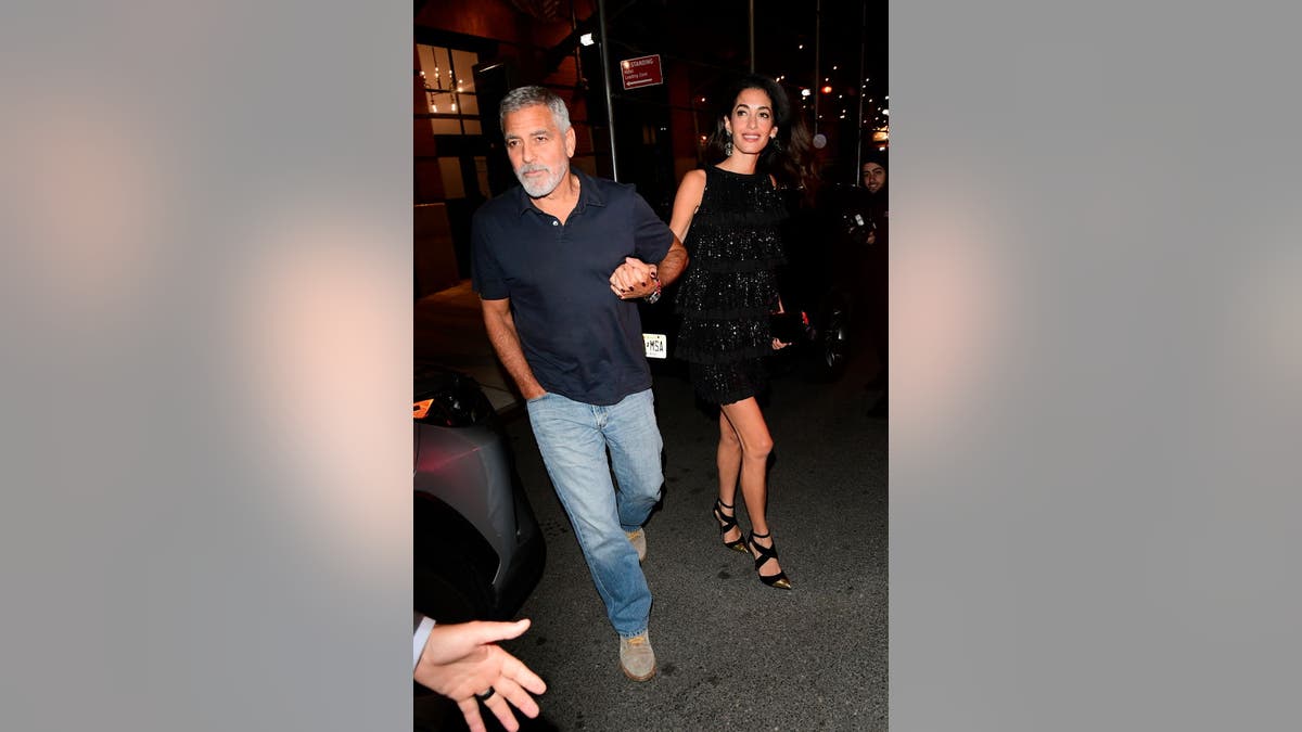 George and Amal Clooney hold hands