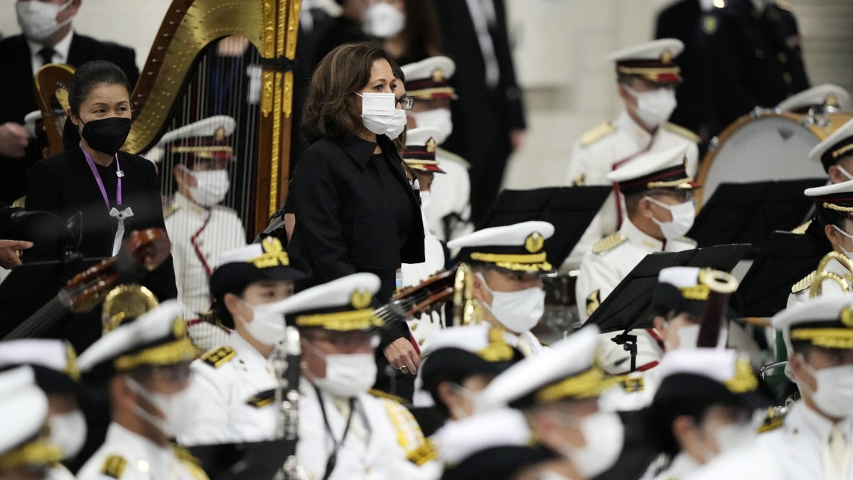 VP Harris wearing black and a face mask in Tokyo