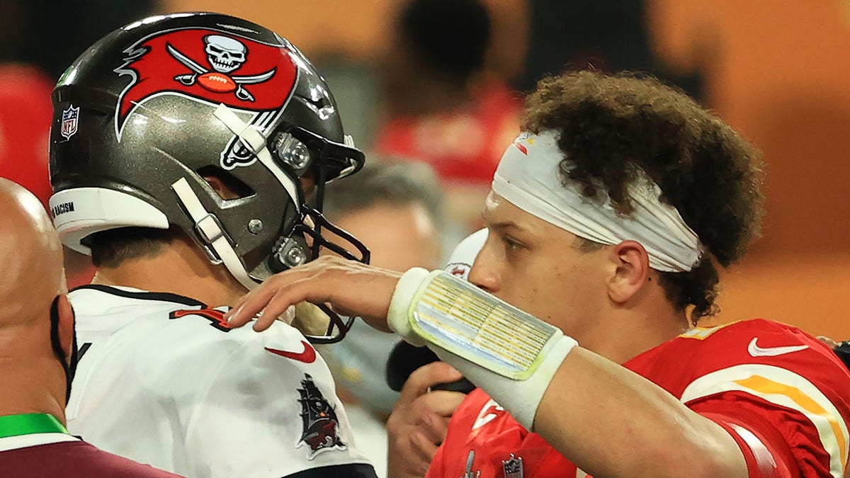 Tom Brady and Patrick Mahomes hug after a game