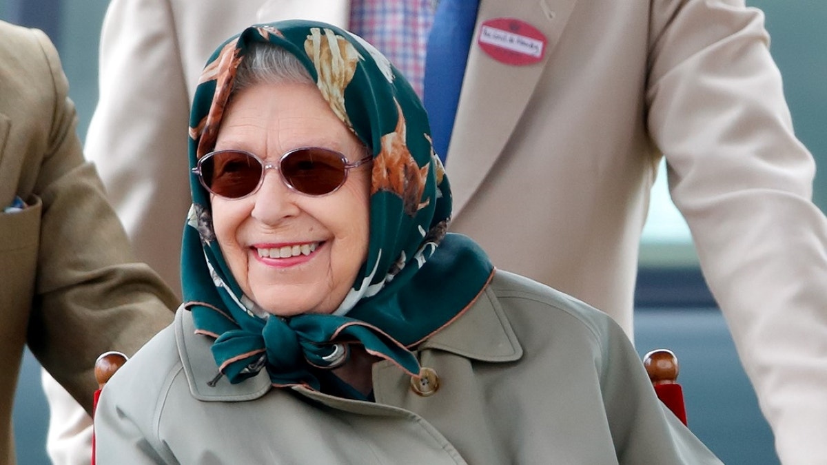 Queen Elizabeth smiling while wearing a scarf