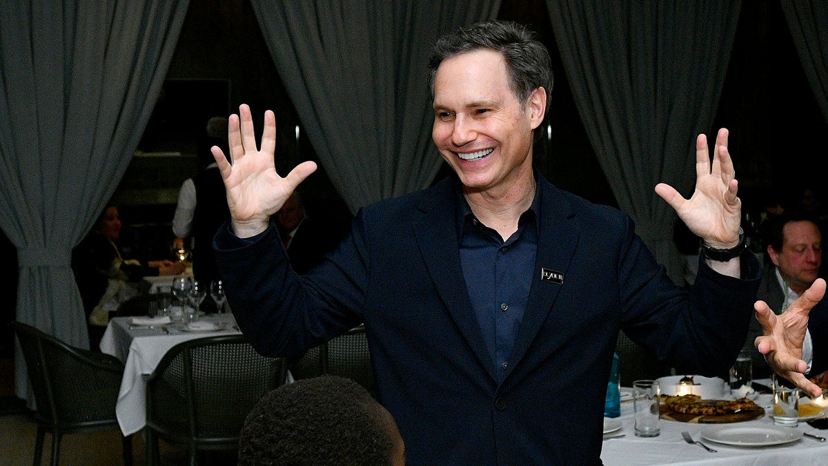 Jason Binn wearing a suit and smiling at an event