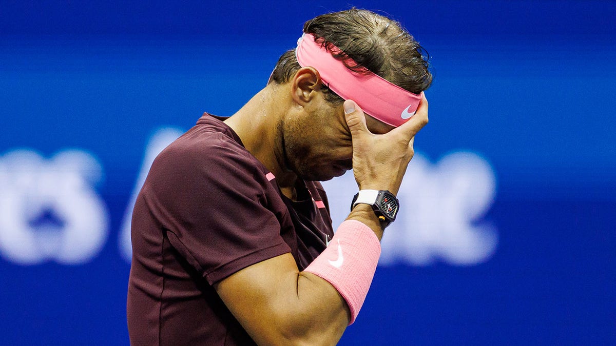 Rafael Nadal grabs his face in pain